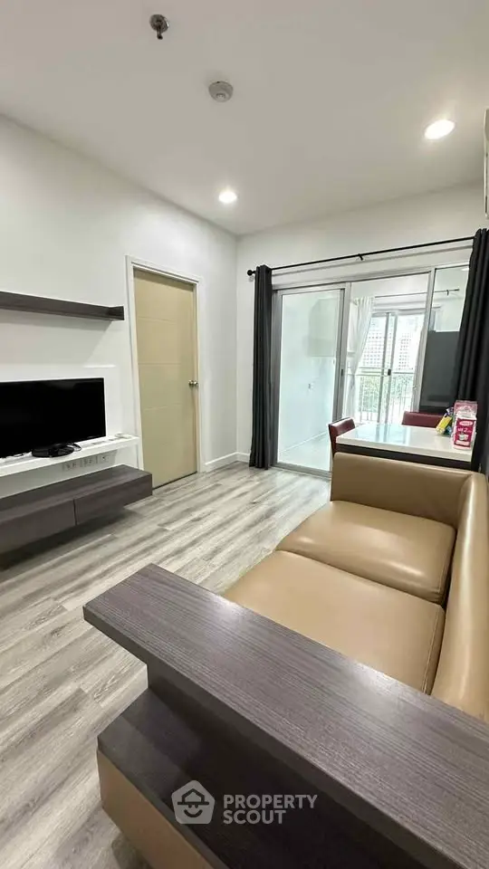 Modern living room with sleek furniture and balcony access in a stylish apartment.