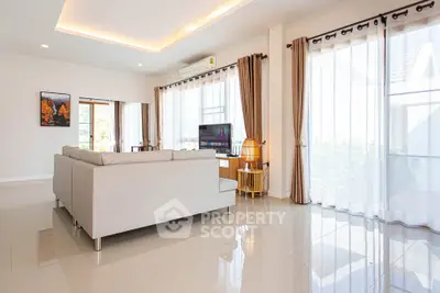Spacious modern living room with large windows and elegant decor