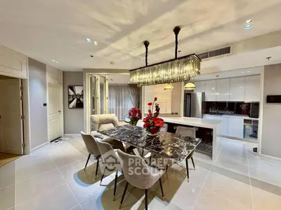 Luxurious open-plan living and dining area with elegant chandelier and modern kitchen.