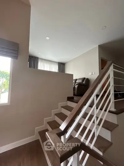 Modern interior with stylish staircase and cozy living area, perfect for contemporary living.