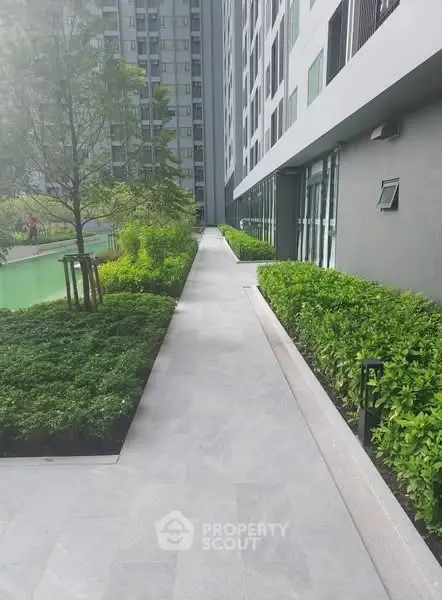 Modern apartment building exterior with lush greenery and walkway