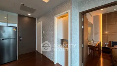 Modern apartment interior with sleek kitchen and dining area, featuring wooden flooring and contemporary design.
