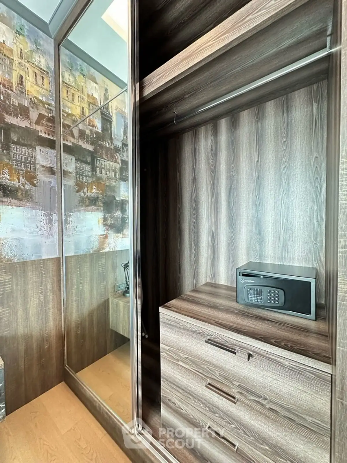 Modern wooden wardrobe with built-in safe and mirrored doors in stylish interior.