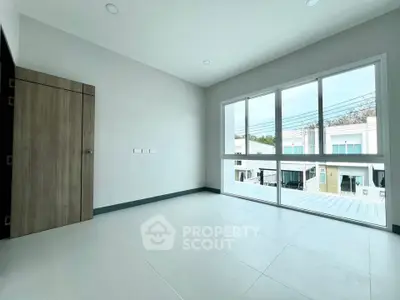 Spacious empty room with large windows offering natural light and modern design.