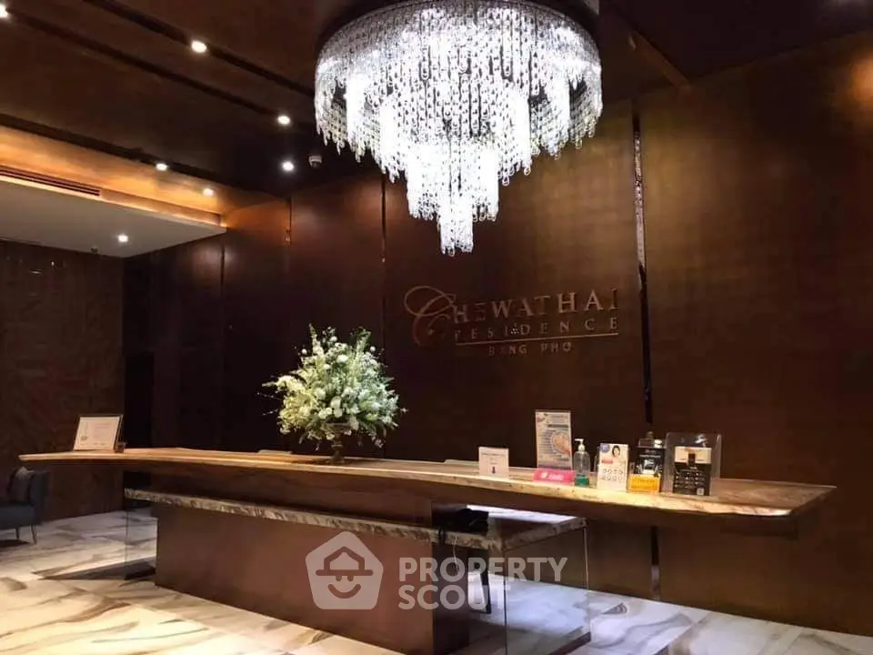 Luxurious lobby with elegant chandelier at Chewathai Residence, showcasing modern design and sophisticated ambiance.