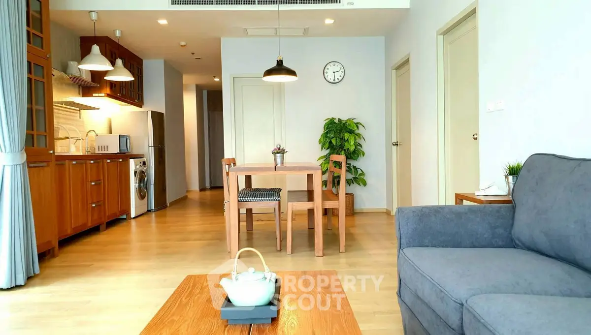 Spacious modern living room with open kitchen and elegant wooden furniture.