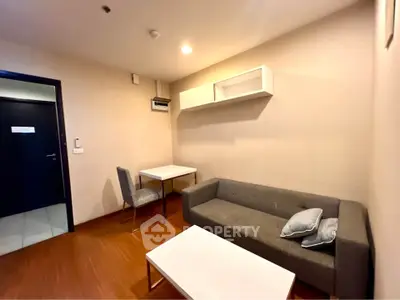 Cozy living room with modern gray sofa and minimalist decor in a stylish apartment.