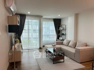 Modern living room with large windows, stylish furniture, and elegant decor.