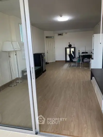 Spacious modern living room with sleek wooden flooring and elegant dining area.