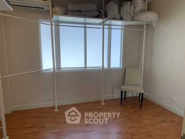 Spacious room with wooden flooring and ample storage space