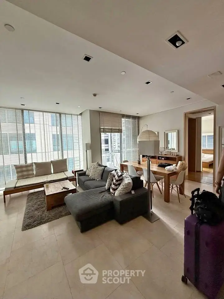 Spacious modern living room with stylish furniture and large windows in a luxury apartment.