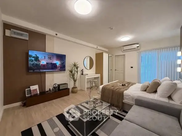 Modern living room with stylish decor, cozy sofa, and wall-mounted TV in a contemporary apartment.