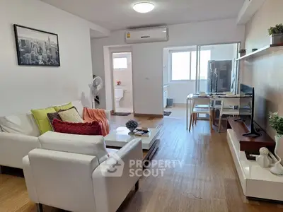 Modern living room with stylish decor and open layout, featuring a cozy seating area and natural light.