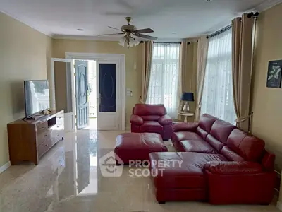 Spacious living room with red leather sofa and natural light
