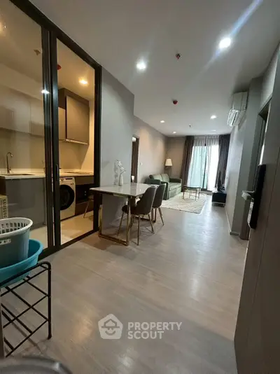 Modern open-plan apartment with sleek kitchen and cozy living area, perfect for urban living.