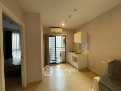 Modern apartment interior with compact kitchen and balcony view