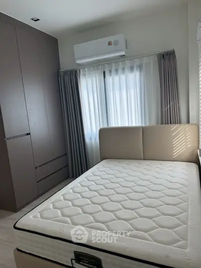 Cozy bedroom with modern furnishings and ample natural light