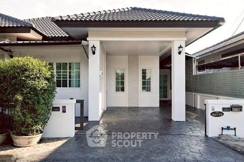 Charming single-story home with modern facade and spacious driveway.