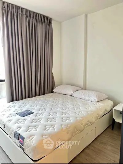 Cozy bedroom with natural light and modern decor, featuring a comfortable bed and elegant curtains.