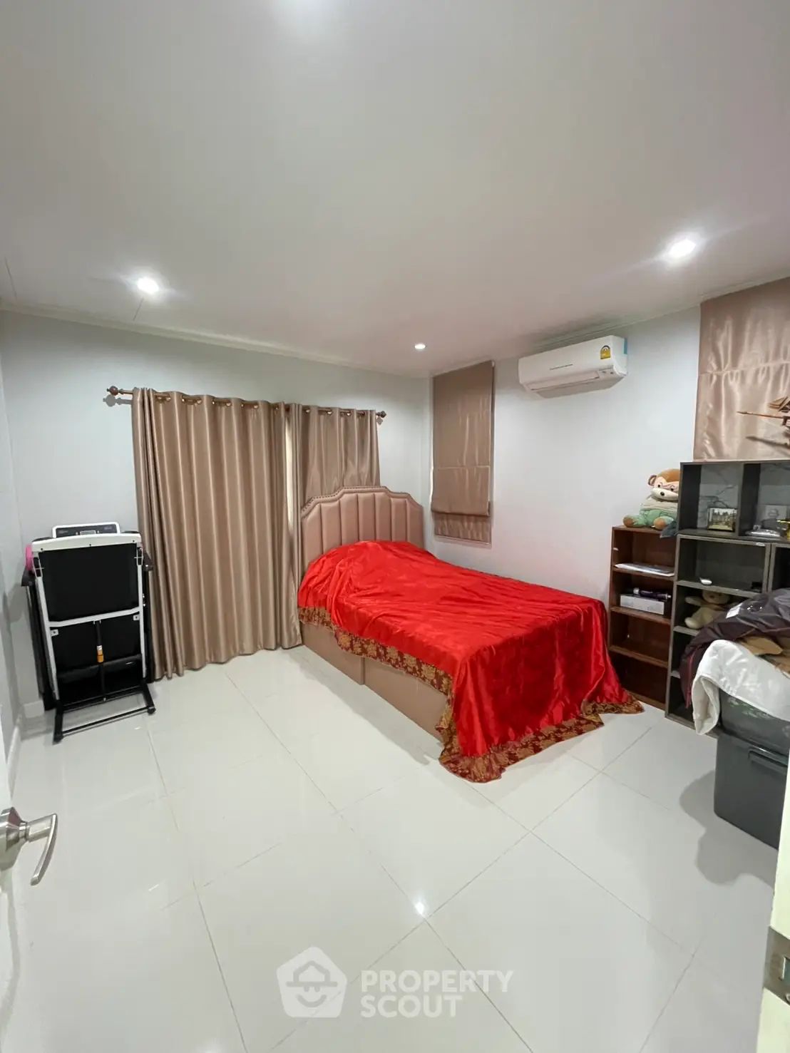 Cozy bedroom with red bedding, air conditioning, and ample storage space.