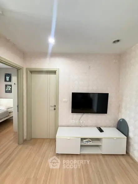 Modern living room with wall-mounted TV and stylish decor in a cozy apartment.