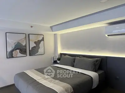 Modern bedroom with stylish decor and air conditioning, featuring elegant artwork and cozy bedding.