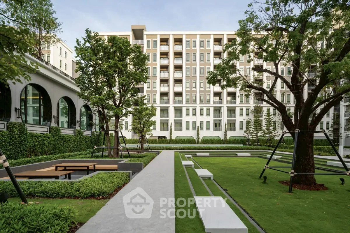 Modern apartment building with lush garden and seating area