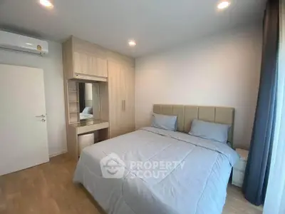 Modern bedroom with stylish decor and ample natural light, featuring a cozy bed and built-in wardrobe.