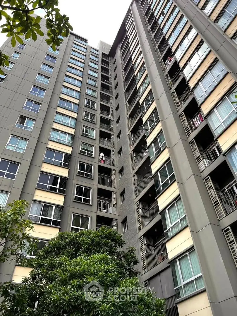 Modern high-rise apartment building with lush greenery and large windows