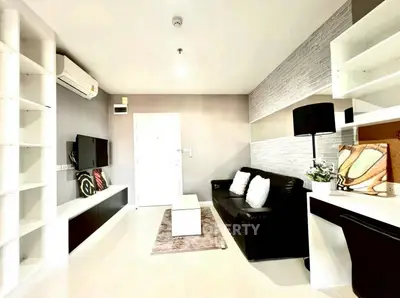 Modern living room with sleek design, featuring a black sofa, wall-mounted TV, and stylish shelving.