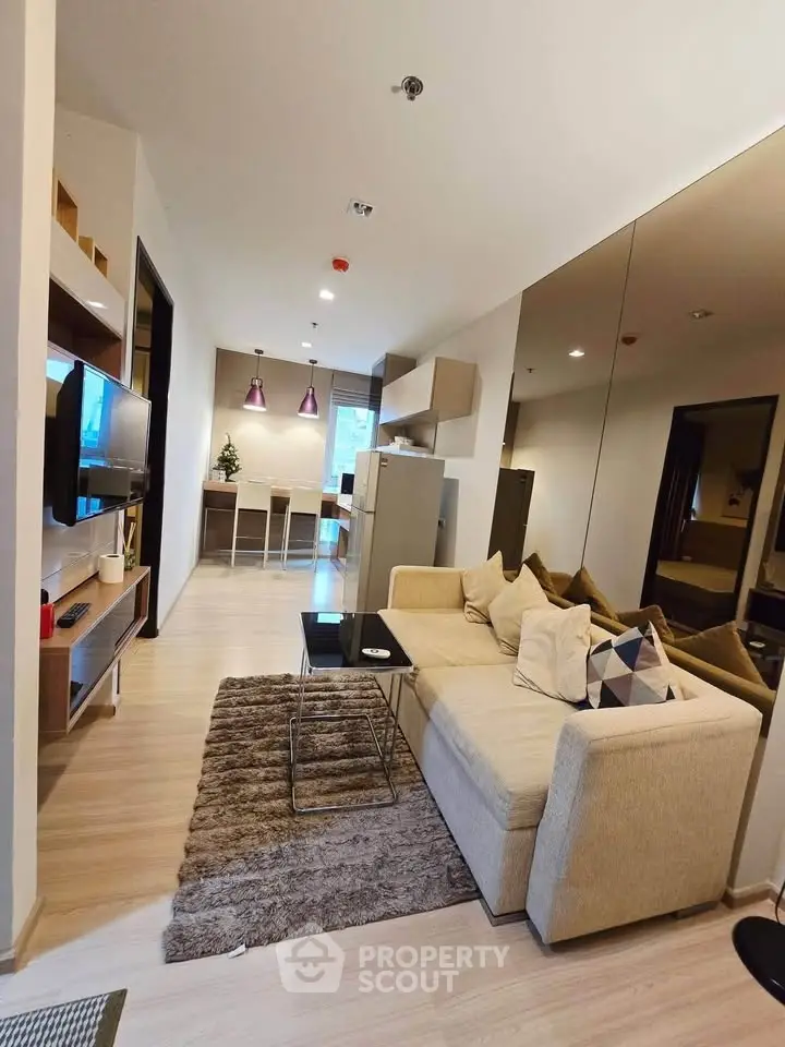 Modern living room with cozy beige sofa and open kitchen layout
