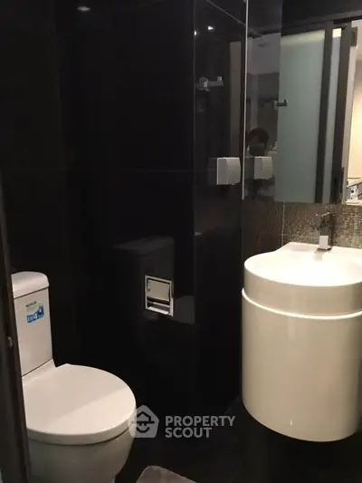 Modern bathroom with sleek black tiles and contemporary fixtures.