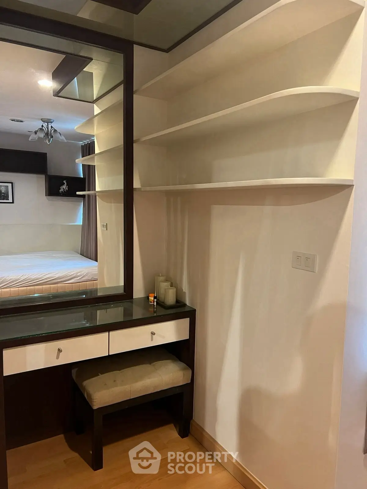 Elegant bedroom with built-in shelves and vanity, featuring modern design and ample storage space.