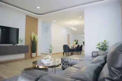 Spacious modern living room with elegant decor and open dining area, perfect for family gatherings.