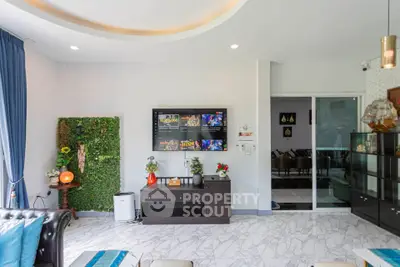 Modern living room with stylish decor and wall-mounted TV, featuring elegant furniture and marble flooring.