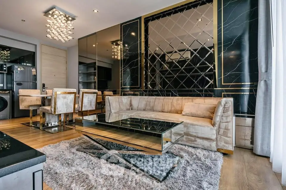 Luxurious modern living room with plush sofa, mirrored coffee table, and elegant lighting in a stylish apartment.