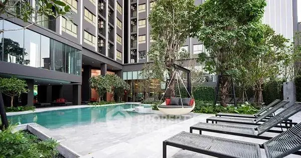 Luxurious condominium pool area with modern design and lush greenery