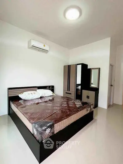 Modern bedroom with sleek furniture and air conditioning in a minimalist design.