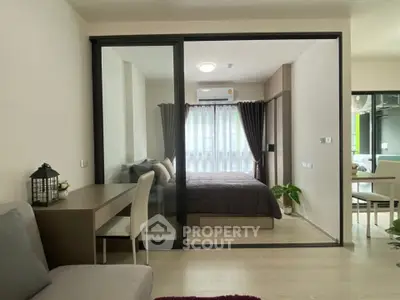 Modern apartment interior with glass partition, cozy bedroom, and stylish living area.