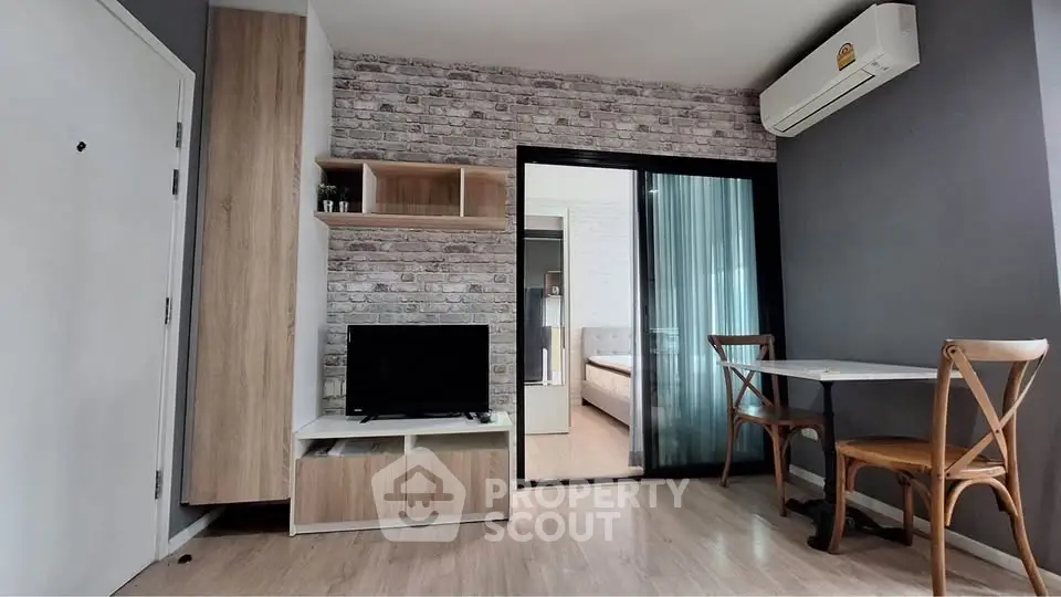 Modern living room with stylish decor and sliding glass door leading to bedroom