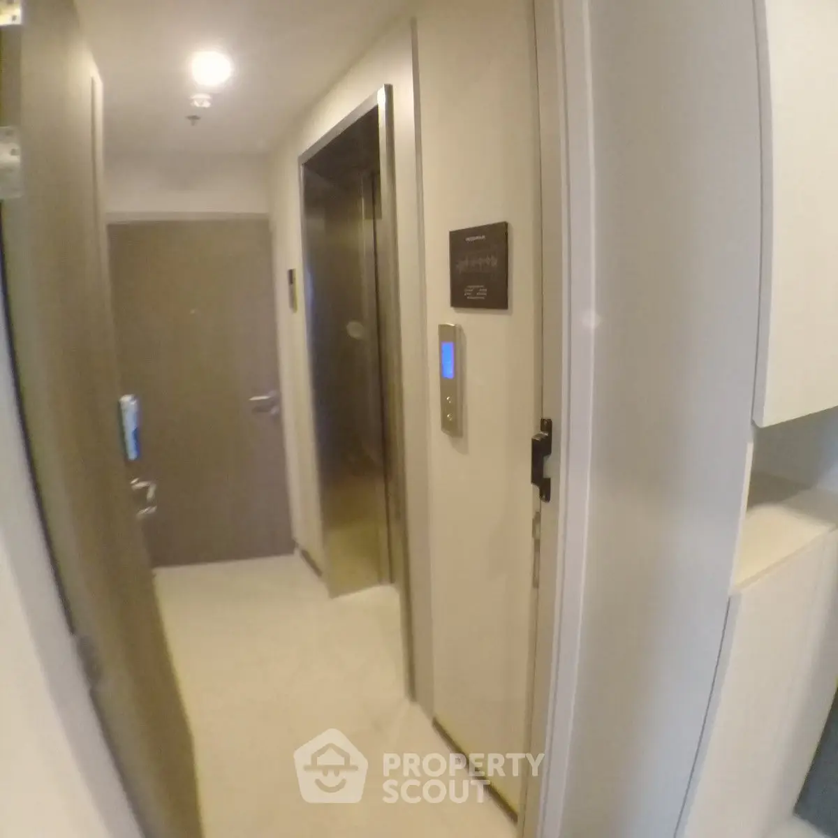 Modern apartment hallway with elevator access and sleek design.