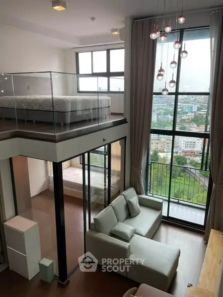 Modern loft apartment with floor-to-ceiling windows and mezzanine bedroom, offering stunning city views.
