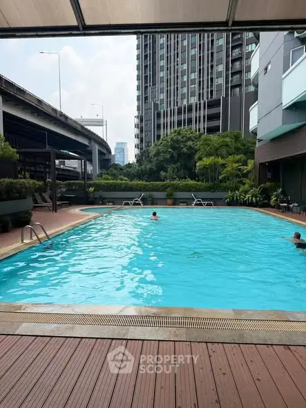 Luxurious urban apartment complex with a stunning outdoor pool and city views.