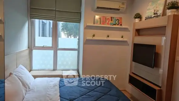 Cozy bedroom with modern decor and wall-mounted TV, featuring a large window for natural light.