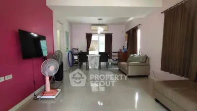 Spacious living room with modern decor and dining area, featuring a wall-mounted TV and air conditioning.