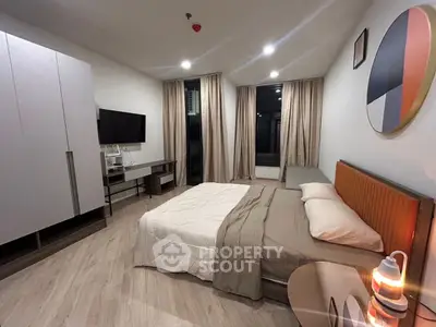 Modern bedroom with stylish decor and large windows in a contemporary apartment.