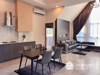 Spacious open-plan living area with modern kitchen, elegant dining set, and cozy lounge space, featuring sleek finishes and ample natural light.