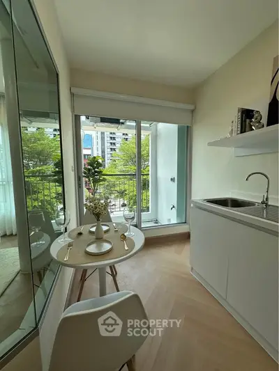 Chic modern kitchen with open layout and balcony view, perfect for urban living.