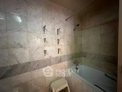 Spacious bathroom with elegant marble tiles and built-in bathtub