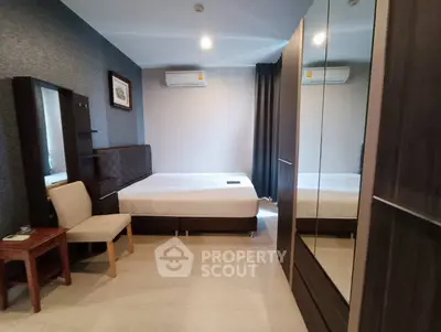 Modern bedroom with stylish furniture and air conditioning, featuring a comfortable bed and mirrored wardrobe.